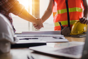 construction worker and business man shaking hands