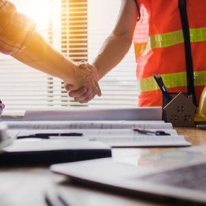 construction worker and business man shaking hands