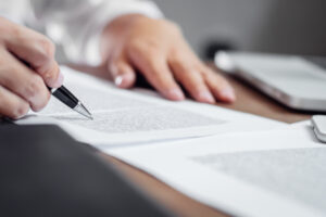 Person reviewing documents with a pen