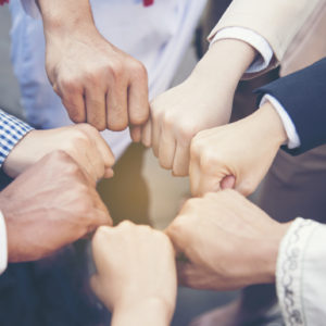 People in business attire fistbumping