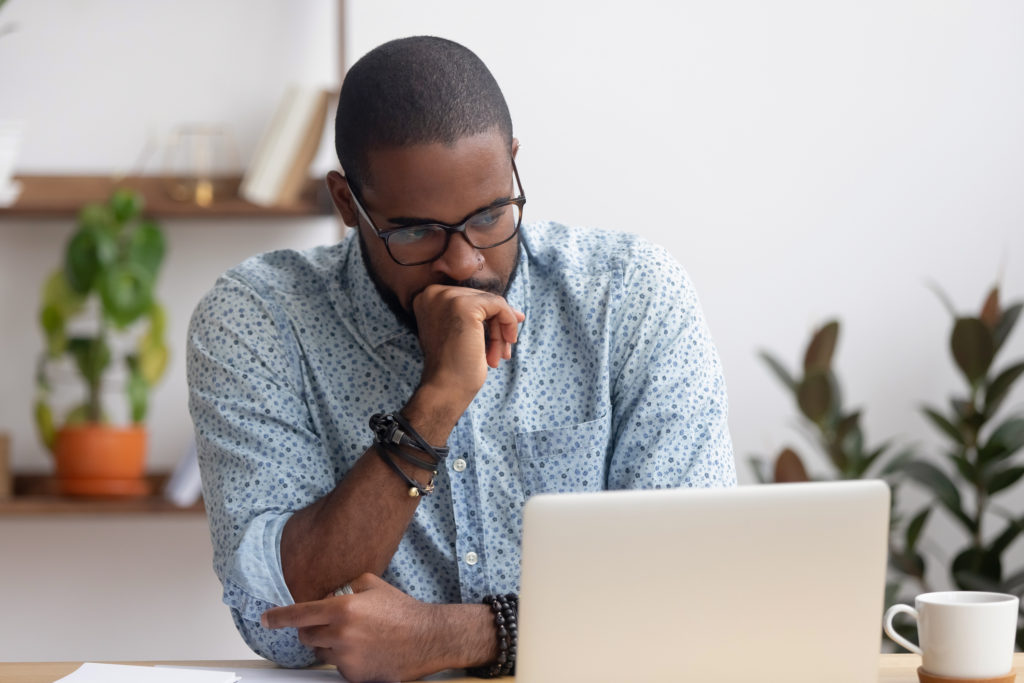 Puzzled man looks at computer