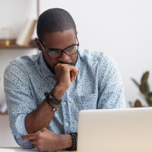 Puzzled man looks at computer