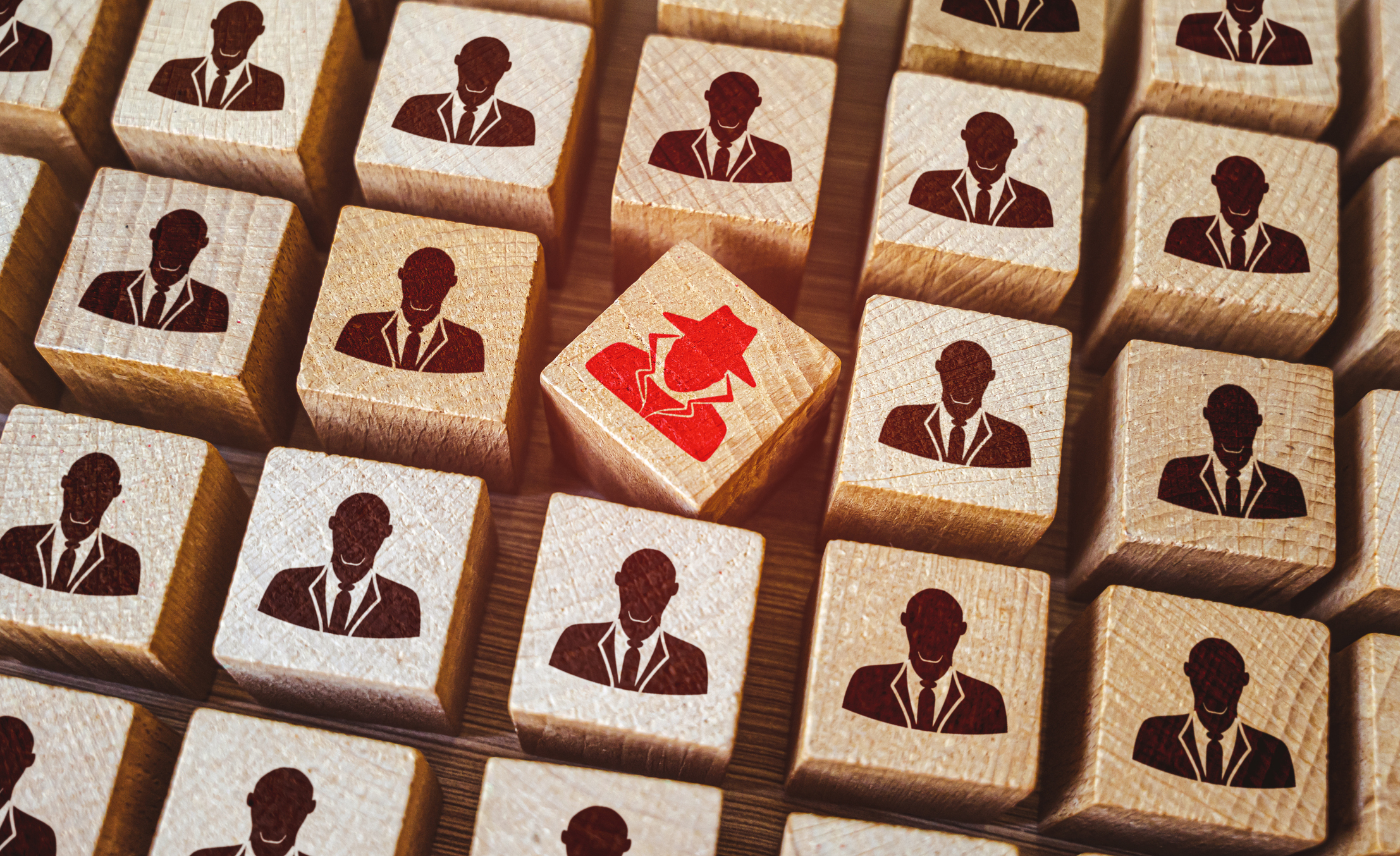 Tiles with black icons of people in a suit. The tile in the middle is tilted and has a red icon of someone in a trench coat and hat