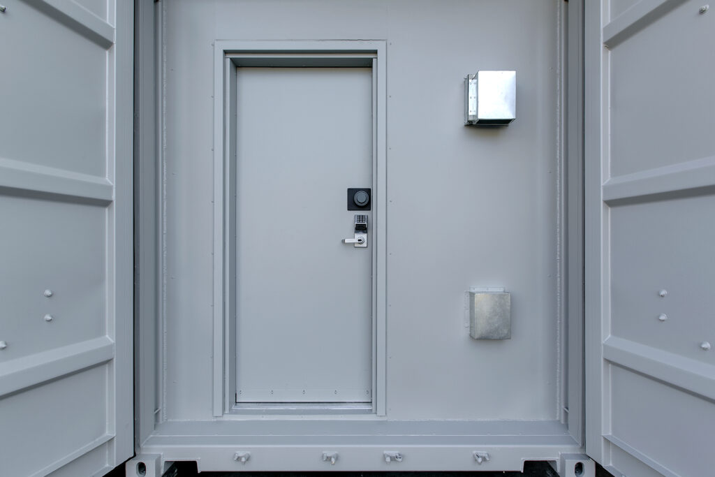 a photo of a door with a spin-dial lock on a container SCIF