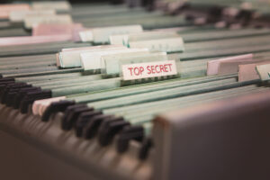 File folders in a filing cabinet. One says "top secret"