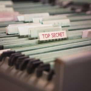 File folders in a filing cabinet. One says "top secret"