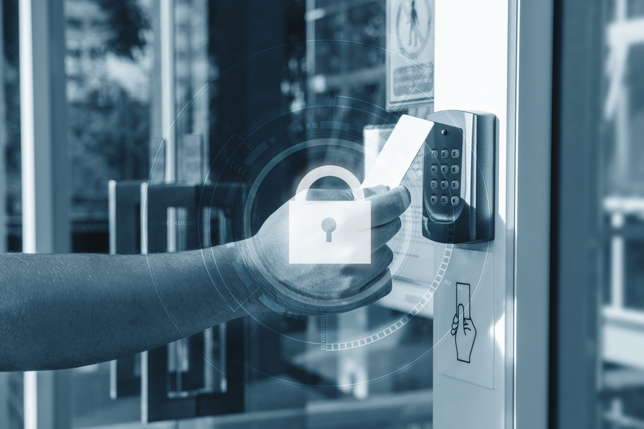 A hand reaching out to scan an access card on a pin pad. There is an overlay graphic with a lock in the center